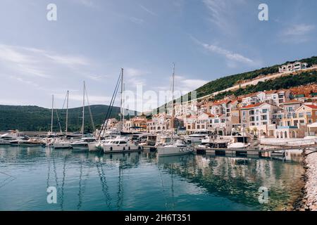 Gli yacht sono ormeggiati in fila al largo della costa della baia di Lustica. Montenegro Foto Stock
