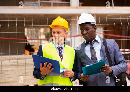 Costruttore e architetto che discutono di costruzione Foto Stock
