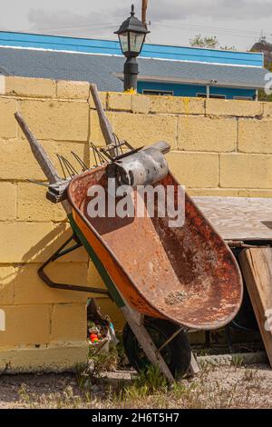 Tonopah, Nevada, Stati Uniti - 16 maggio 2011: Storico Parco minerario. Primo piano della carenatura della ruota arancione arrugginita contro la parete di pietra gialla. Foto Stock