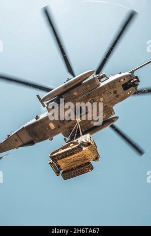 Un caricatore di pista compatto del corpo di Marina degli Stati Uniti assegnato allo Squadron di supporto dell'ala di Marina (MWSS) 172, la prima ala di velivolo di Marina, è attaccato al fondo il fondo di un elicottero di Stallion di CH-53E Super mentre è sollevato esterno durante un'esercitazione di campo al centro di addestramento di Jungle Warfare, campo Gonsalves, Okinawa, Giappone, 3 novembre 2021. MWSS-172 ha tenuto questo esercizio al fine di dimostrare una prova di concetto per gli ascensori esterni, di sviluppare il concetto Expeditionary Advanced base Operations e di migliorare l’efficacia della lotta della società di ingegneria in un ambiente di guerra nella giungla. (STATI UNITI Cor. Marino Foto Stock