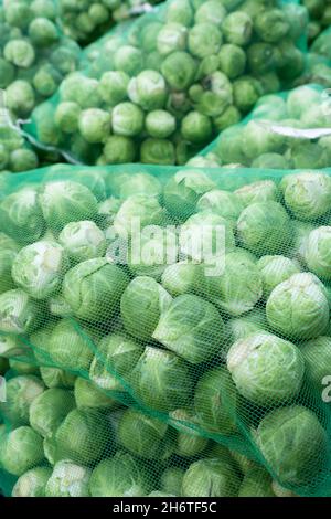 Reti piene di germogli di brussel freschi e verdi esposti in un negozio di verdure Foto Stock