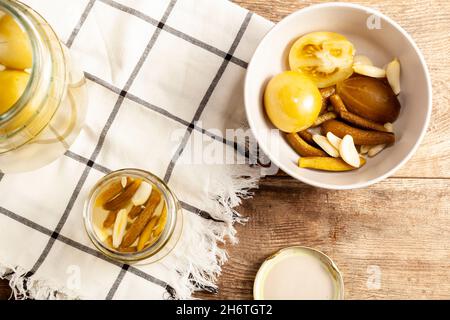 Immagine piatta che mostra una ciotola con zucca sottaceto e pomodori. Immagine concettuale per decapaggio, probiotici, cibo delizioso e sano Foto Stock