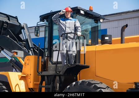 Escavatore in cavalletti per elmetto in attrezzature da costruzione, ritratto uomo industriale concetto. Foto Stock