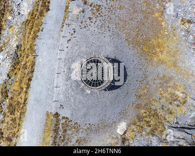 Vecchio pozzo di miniera di carbone abbandonato. Fine dell'industria mineraria ha fissato un limite per rendere sicuro alla cava di ardesia. Vista aerea dal drone di industriale spoky scuro Foto Stock
