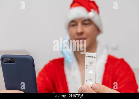 Uomo vestito con cappello Babbo Natale che mostra il risultato del test Foto Stock