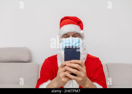 Vestito come Babbo Natale che parla tramite videoconferenza Foto Stock