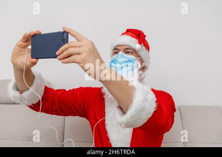 Vestito come Babbo Natale che parla tramite videoconferenza Foto Stock