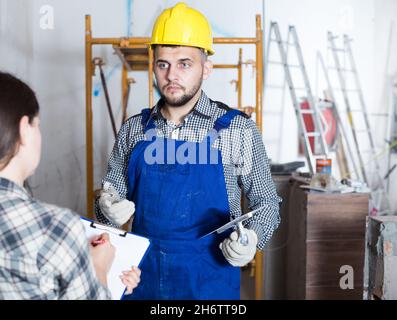 Il lavoratore professionale con la spatola sta chiarendo i dettagli dal cliente Foto Stock