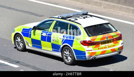 Primo piano vista aerea laterale e posteriore di Essex polizia pattuglia auto guida lungo l'autostrada inglese con riflettente ad alta visibilità battenberg marcature UK Foto Stock