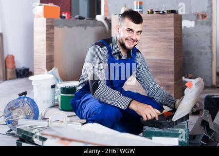 Il lavoratore sta scegliendo gli attrezzi in valigia per il lavoro all'oggetto. Foto Stock