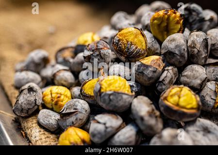 Mucchio di castagne deliziose arrostite al fuoco a Faro, Portogallo Foto Stock