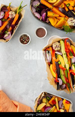Verdure fresche tritate cucinate al forno in vari piatti di ceramica, vista dall'alto Foto Stock