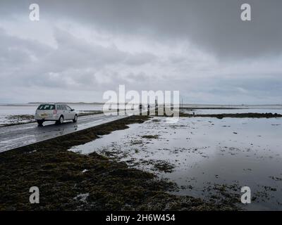 Auto attraversando Lindisfarne Causeway una strada di marea che collega la storica Holy Island di Lindisfarne con la terraferma del Northumberland Inghilterra UK Foto Stock