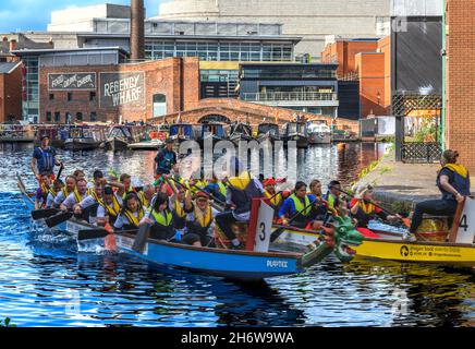 Dragon boat racing sul canale di Birmingham Old Line al gas Street Basin nel cuore di Birmingham. Regency Wharf è sullo sfondo. Foto Stock