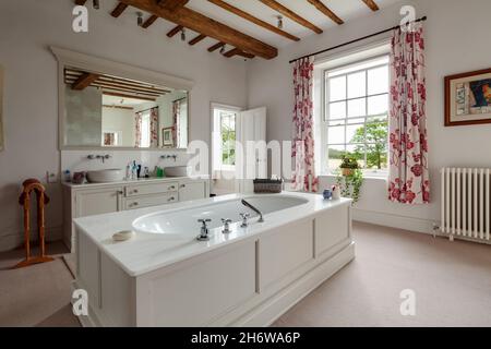 Wimbish, Inghilterra - Luglio 30 2019: Bagno in sede inglese. Doppio lavello su armadio, travi a vista, grande finestra multi-panato Foto Stock