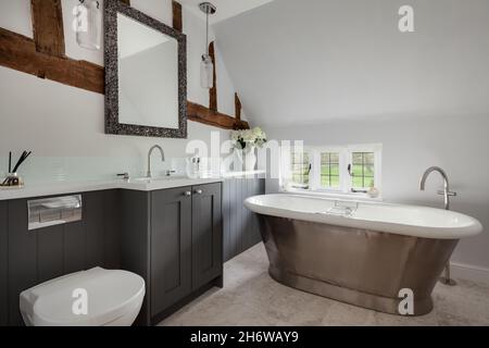 Essex, Inghilterra - Gennaio 18 2019: Bagno tradizionale con bagno in metallo roll bordo vasca, travi in legno a vista e piccola finestra con piombo Foto Stock