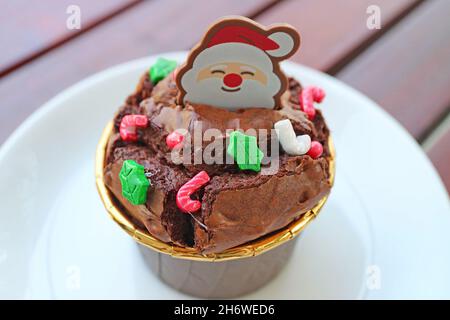 Primo piano di Cupcake al cioccolato con Santa Choco e Christmas Sprinkles Foto Stock