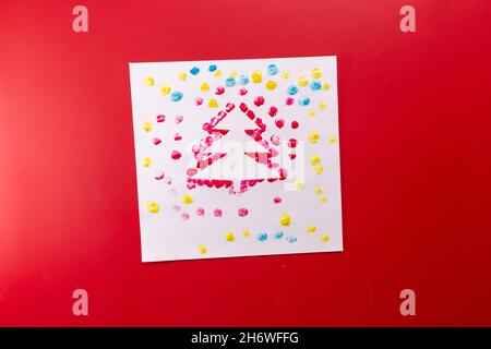 Albero di Natale impronta artigianale, attività semplice per i bambini, sfondo rosso Foto Stock