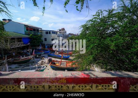 Piccole e colorate barche da pesca thailandesi sono ormeggiate su una piccola spiaggia vicino al centro della città di Hua Hin, Thailandia. Foto Stock