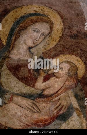 Santa Maria succhia il bambino Gesù in un affresco lombardo tardo medievale della Madonna e del Bambino nell'ex Chiesa dei Santi Giovanni e Reparata in Piazza San Giovanni, Lucca, Toscana, Italia. La basilica, oggi museo, fu ricostruita nel XII secolo sul sito di antichi edifici romani e di una chiesa e battistero paleocristiani che servivano come cattedrale originaria della città. Foto Stock