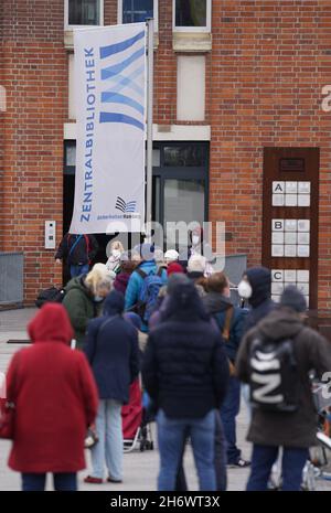 18 novembre 2021, Amburgo: Le persone disposte ad essere vaccinate attendono l'ammissione di fronte alla Biblioteca Centrale di Amburgo durante una campagna di vaccinazione. Durante una campagna di vaccinazione nella biblioteca centrale delle sale del libro nel centro della città, diverse centinaia di persone si sono accodate intorno a mezzogiorno. La coda si allungava attraverso il piazzale circa 200 metri in una strada laterale. (Al dpa 'lunga coda all'azione di vaccinazione nelle sale del libro di Amburgo') Foto: Marcus Brandt/dpa Foto Stock