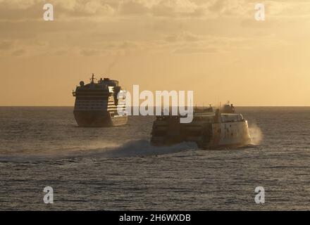 26 ottobre 2021, Spagna, tenero: La nave da crociera Aida bella (l) attende al mattino prima di entrare nella posizione di ormeggio nel porto di Santa Cruz de Tenerife. Il traghetto Armas passa sulla destra. L'AIDAbella, che naviga sotto Aida Cruises, appartiene a Carnival Corporation & plc. La nave club della flotta da crociera è stata costruita presso il cantiere Meyer di Papenburg, la deposizione della chiglia è stata effettuata nel 2007. Foto: Soeren Stache/dpa-Zentralbild/ZB Foto Stock