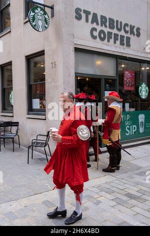 I soldati cerimoniali si accaparrano per un caffè a Starbucks prima di impartire il Lord Mayor's Show nella City di Londra, il distretto storico e finanziario della capitale, il 13 novembre 2021, a Londra, Inghilterra. Alderman Vincent Keaveny è stato eletto come il 693 Signore Sindaco della città di Londra. Lo spettacolo risale al XIII secolo, quando il re Giovanni consentì all'antica città di Londra di nominare il proprio sindaco e ogni sindaco appena eletto ha fatto lo stesso viaggio annuale per le strade per oltre 800 anni. Foto Stock