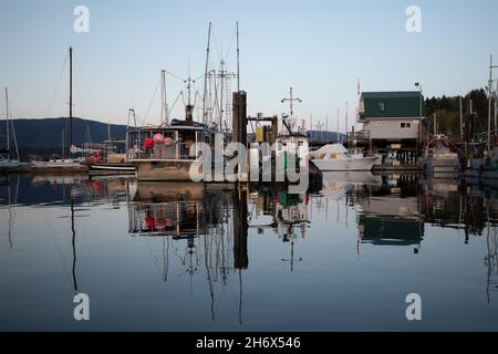 Un molo di pesca vicino al tramonto con le barche legate al molo, Cowichan Bay, Vancouver Island, Canada Foto Stock