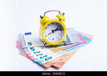 concetto di business, orologio con bollette di denaro su sfondo bianco, isolare Foto Stock