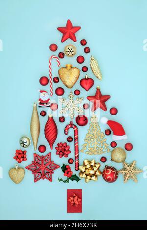 Albero di Natale astratto concetto forma con oro e rosso brillante bauble decorazioni e ornamenti su sfondo blu. Foto Stock