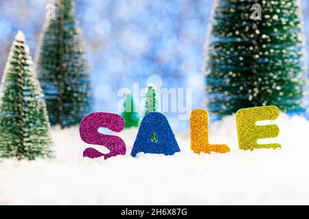 Offerta di Natale. LA VENDITA di iscrizione nella neve sullo sfondo di alberi di abete verde nella neve Foto Stock