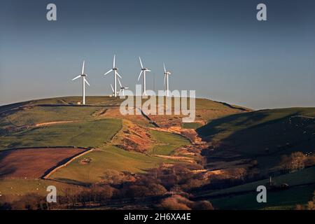 Wind farm sulla cima della montagna alla luce della sera Foto Stock