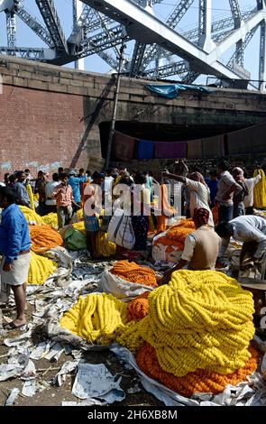 Commercianti nel mercato dei fiori di Howrah con marigolds e offerte di puja, Kolkata, India Foto Stock