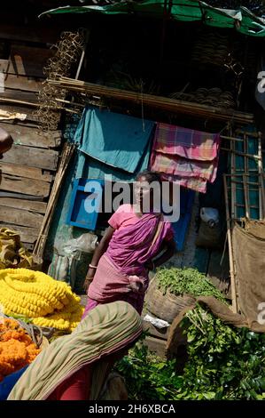 Fiorista donna indiana matura che vende fiori nel mercato dei fiori di Howrah Calcutta Foto Stock