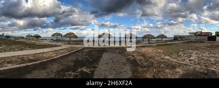 Scatto panoramico della spiaggia con ombrelloni di paglia. Foto Stock