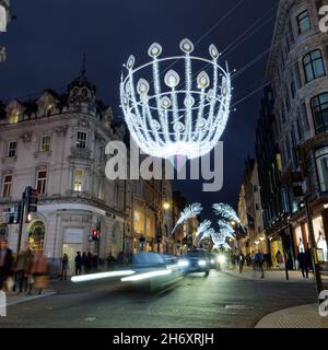 Londra, Greater London, Inghilterra, novembre 13 2021: Luci di Natale su New Bond Street di notte come le automobili stripaia vicino su una lunga esposizione. Foto Stock