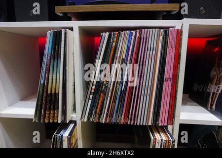 Mucchio di molti dischi in vinile in piedi vicino in vecchie copertine di carta a colori sul primo piano della vista laterale del ripiano. Foto di alta qualità Foto Stock