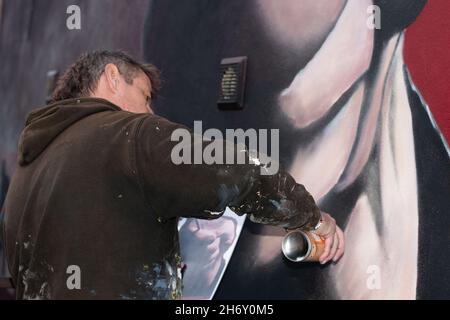 16 novembre 2021, Cheltenham, Inghilterra, High Street Car Park. L'artista Andy 'dice' Davies dipinge un murale a sorpresa per il cantante Jaz Coleman, della band punk degli anni '80 che uccide Joke. Foto Stock