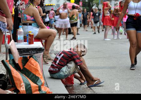 Brasile–22 febbraio 2020:un ragazzo che indossa una maglia della squadra di calcio Flamengo osserva i festeggiamenti in costume durante una sfilata di carnevale di strada che si tiene a Rio de Janeiro Foto Stock