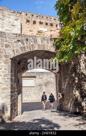 Pellegrini che camminano attraverso le porte della città a Camino de Santiago la via del pellegrinaggio di San Giacomo attraverso la città spagnola di Pamplona Navarra Spagna Foto Stock