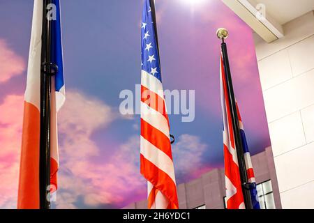 Bandiere nazionali di diversi paesi (Stati Uniti d'America, Regno Unito e Federazione russa) contro il cielo colorato. Politica un Foto Stock