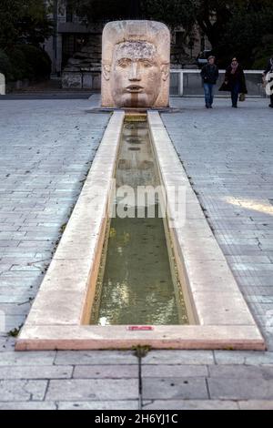 NIMES, FRANCIA - 6 NOVEMBRE 2021: Fontana Place d'Assas a Nîmes, nel sud della Francia, statua di una testa Foto Stock