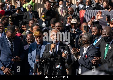 Brunswick, Stati Uniti. 18 Nov 2021. Il Rev. Al Sharpton, al centro, si rivolge alla folla accanto ai genitori di Ahmaud Arbery; Wanda Cooper-Jones, a sinistra, e Marcus Arbery, a destra, Come più di 500 pastori neri e sostenitori si sono riuniti fuori dal Glynn County Courthouse 18 novembre 2021 a Brunswick, Georgia. Il processo degli imputati Greg McMichael, Travis McMichael, e un vicino, William 'Roddie' Bryan continuò all'interno del tribunale. Credit: Planetpix/Alamy Live News Foto Stock