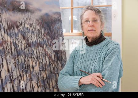 Ritratto di una donna anziana in pensione nel suo studio d'arte Foto Stock