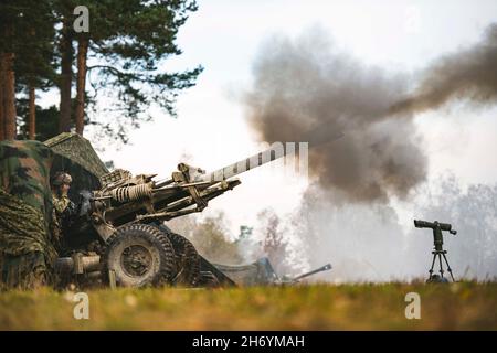 Grafenwoehr, Germania. 25 ottobre 2021. I paracadutisti dell'esercito degli Stati Uniti hanno assegnato al 4° Battaglione, il 319° Airborne Field Artillery Regiment fuoco un M119A3 Howitzer durante un'esercitazione di fuoco vivo dell'artiglieria da campo. Questa formazione fa parte dell'esercizio Bayonet Ready 22 presso il Joint Multinational Training Center nella Grafenwoehr Training Area, Germania, dal 25 ottobre 2021. Exercise Bayonet Ready 22 è una direttiva della Task Force Africa dell'Esercito del Sud dell'Europa degli Stati Uniti condotta dal 7° comando di addestramento dell'Esercito e dalla 173° Brigata Airborne presso il Joint Multinational Readiness Center nell'area di addestramento di Hohenfels, Foto Stock