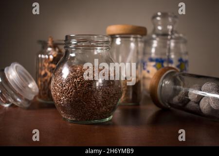 Spezie diverse in alcune bottiglie di vetro su un tavolo Foto Stock