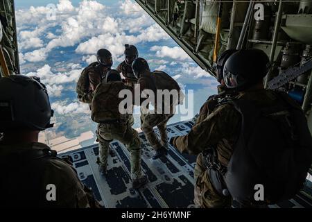 Moody Air Force base, Georgia, USA. 22 ottobre 2021. I parasercuemen dell'aeronautica degli Stati Uniti assegnati al 38° Squadrone di salvataggio si preparano a saltare in una formazione collegata da un re di combattimento HC-130J II vicino alla base dell'aeronautica di Moody, Georgia, 22 ottobre 2021. I PJS sono qualificati per eseguire salti con bassa apertura sia statici che ad alta quota. La missione del 38° RQS è quella di impiegare ufficiali di salvataggio pronti da combattimento e pararescuemen per sostenere le unità di tutto il mondo. Credit: U.S. Air Force/ZUMA Press Wire Service/ZUMAPRESS.com/Alamy Live News Foto Stock