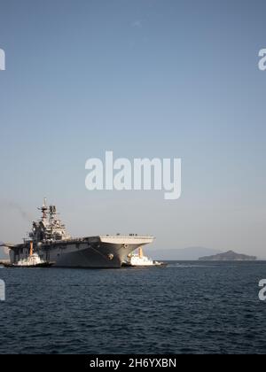 La USS America (LHA 6), l’unica nave d’assalto anfibio dispiegata in avanti della Marina, entra nel porto presso la Marine Corps Air Station Iwakuni, Giappone, 18 novembre 2021. Grazie alla sua posizione geografica e al suo giacimento aereo e porto, MCAS Iwakuni è stato solo in grado di fornire l'integrazione navale avanzata a sostegno della sicurezza regionale. L'America, ammiraglia dell'America Expeditionary Strike Group sta operando nell'area di responsabilità della 7a flotta degli Stati Uniti per migliorare l'interoperabilità con alleati e partner, e serve come una forza di risposta pronta a difendere la pace e la stabilità nella regione IndoPacifico Foto Stock