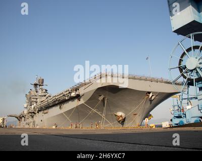 La USS America (LHA 6), l’unica nave d’assalto anfibio dispiegata in avanti della Marina, attracca al porto della Marine Corps Air Station Iwakuni, Giappone, 18 novembre 2021. Grazie alla sua posizione geografica e al suo comlocazione di aeroporto e porto, MCAS Iwakuni è stato solo in grado di fornire una avanzata integrazione navale a sostegno della sicurezza regionale. L'America, ammiraglia dell'America Expeditionary Strike Group, opera nell'area di responsabilità della settima flotta degli Stati Uniti per migliorare l'interoperabilità con alleati e partner, e funge da pronta forza di risposta per difendere la pace e la stabilità nella regione IndoPacifico. Foto Stock