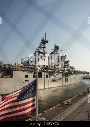 La USS America (LHA 6), l’unica nave d’assalto anfibio dispiegata in avanti della Marina, entra nel porto presso la Marine Corps Air Station Iwakuni, Giappone, 18 novembre 2021. Grazie alla sua posizione geografica e al suo giacimento aereo e porto, MCAS Iwakuni è stato solo in grado di fornire l'integrazione navale avanzata a sostegno della sicurezza regionale. L'America, ammiraglia dell'America Expeditionary Strike Group sta operando nell'area di responsabilità della 7a flotta degli Stati Uniti per migliorare l'interoperabilità con alleati e partner, e serve come una forza di risposta pronta a difendere la pace e la stabilità nella regione IndoPacifico Foto Stock